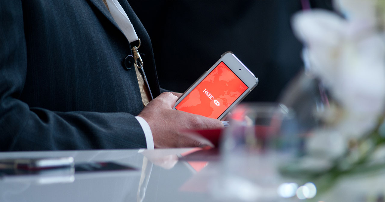 Man in a suit holding an iPod with HSBC logo on the screen